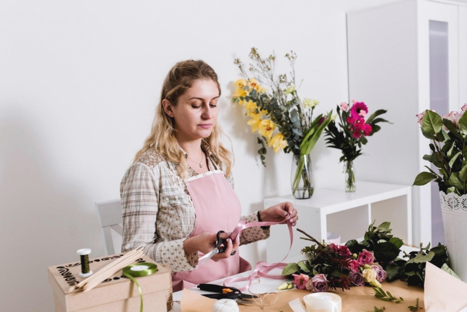 Florist arranging stems in parallel grid formation on a workshop table